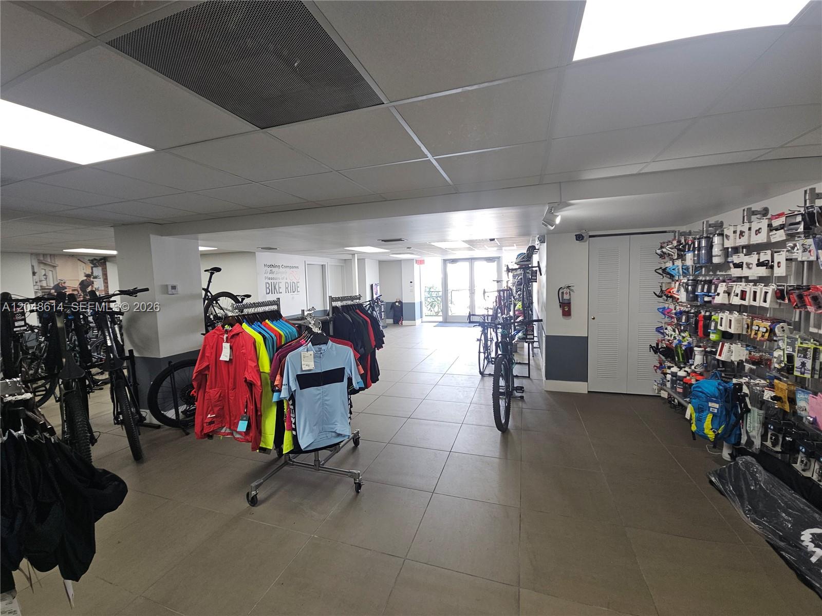 A retail bike shop features clothing racks, bicycles, and wall-mounted accessories on tiled floors — 7890 NW 34th St, Doral FL 33122, DORAL, FL