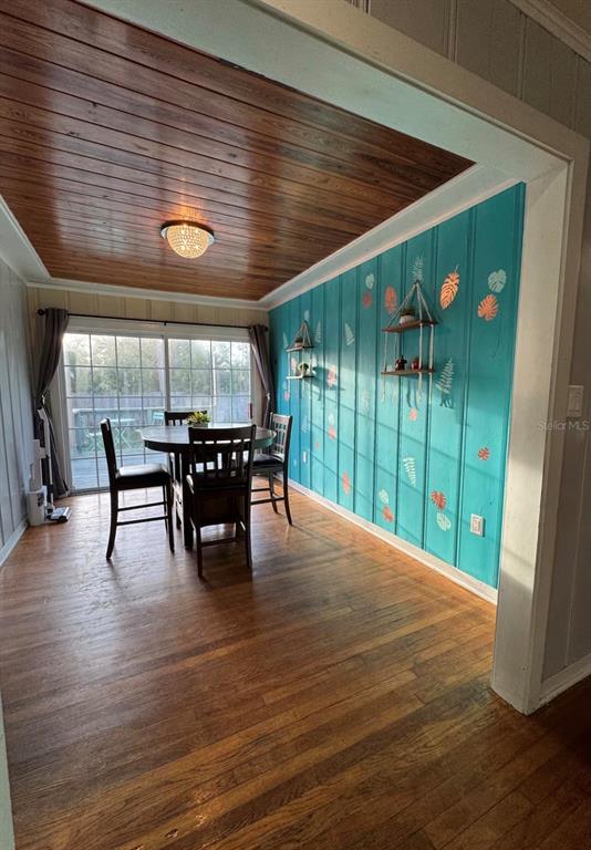 A dining room features a wood-paneled ceiling, hardwood floors, and a teal accent wall — 1564 S MICHIGAN AVENUE, CLEARWATER, FL