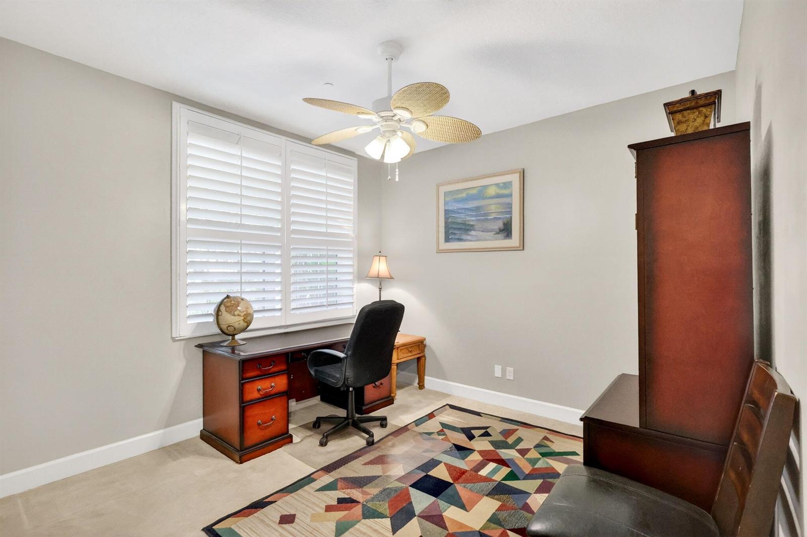A home office features a wooden desk, a black chair, a ceiling fan, and a rug — 540 SW Akron Avenue, Stuart FL 34994, STUART, FL
