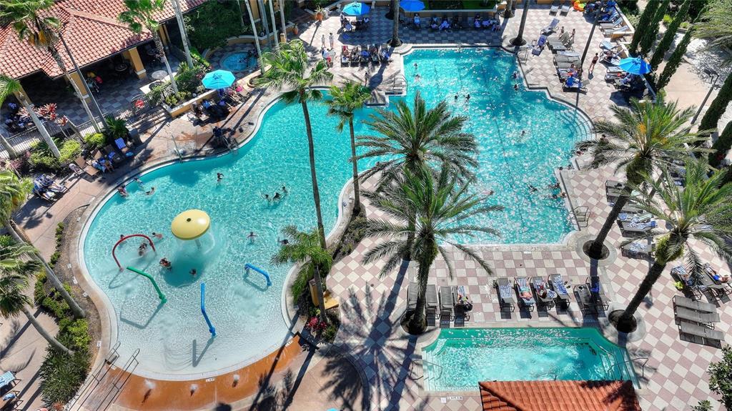 An aerial view shows a resort-style swimming pool complex with palm trees and lounge chairs — 12544 FLORIDAYS RESORT DRIVE UNIT 508B, ORLANDO, FL