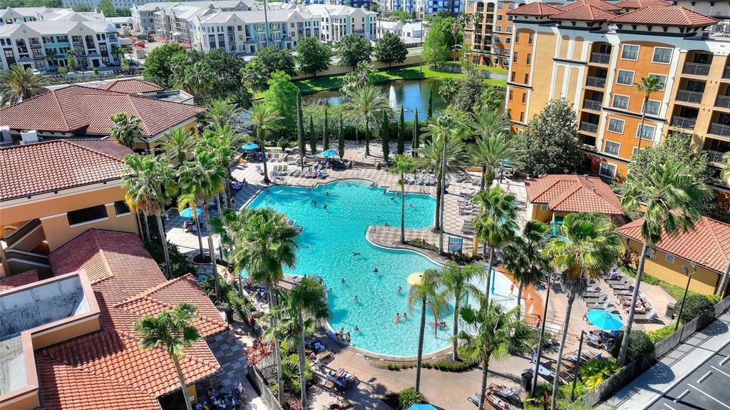 An aerial view of a large resort-style swimming pool surrounded by palm trees and buildings — 12544 FLORIDAYS RESORT DRIVE UNIT 508B, ORLANDO, FL