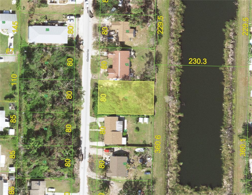 This is an aerial map showing a vacant lot highlighted in yellow along a canal — 1845 SHADOW LANE, ENGLEWOOD, FL