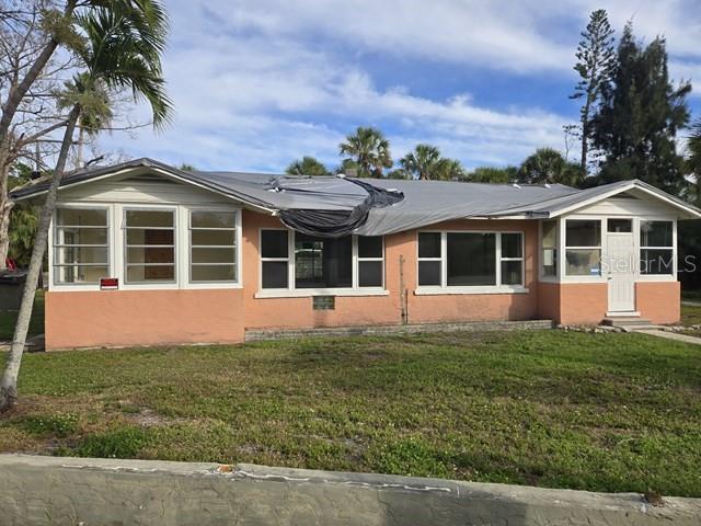 A single-story peach-colored house with a tarp covering a portion of the roof — 3615 HIGEL AVENUE, SARASOTA, FL