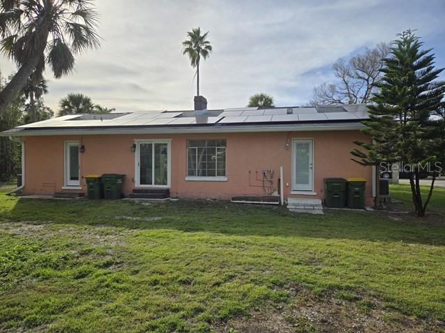 The exterior of a peach-colored house features a solar panel array on the roof — 3615 HIGEL AVENUE, SARASOTA, FL