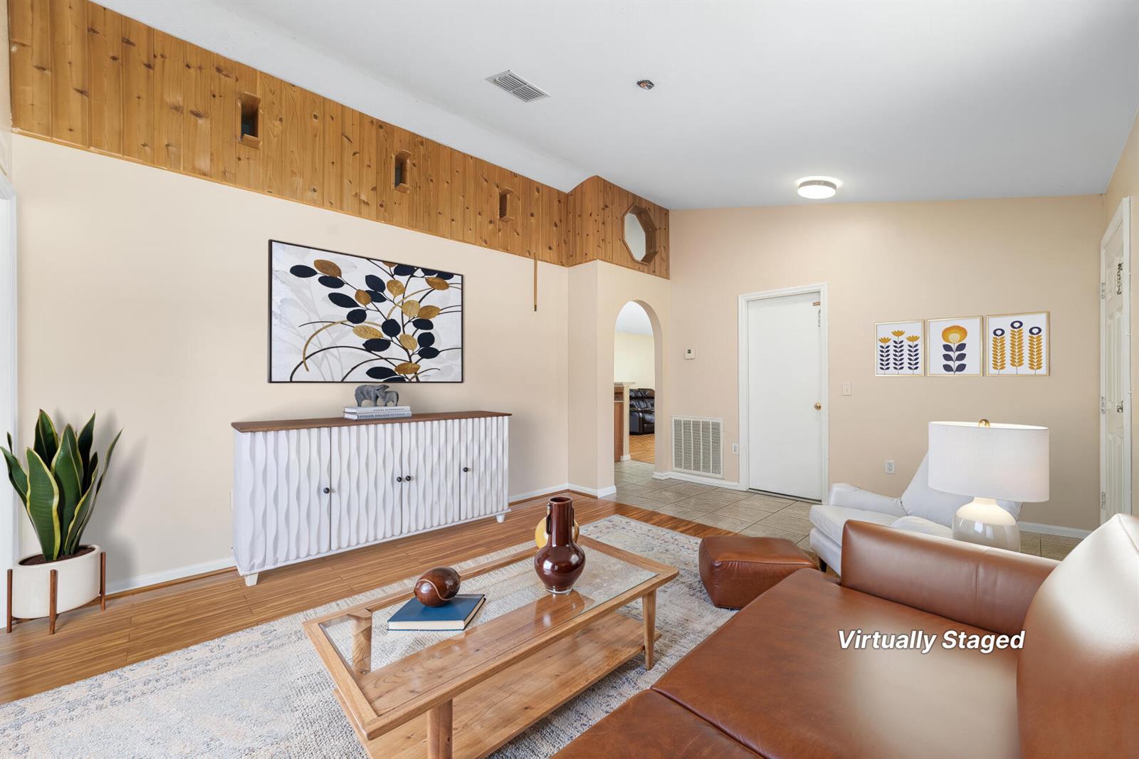 A living room features wood-paneled upper walls, a white sideboard, and a leather sofa — 1165 SE 40th Avenue, Okeechobee FL 34974, OKEECHOBEE, FL