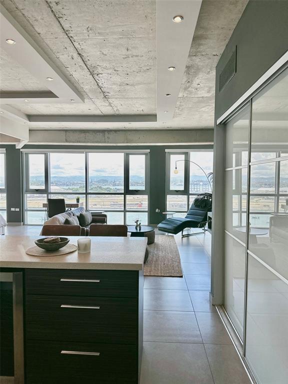 A modern apartment interior features a kitchen island, living area, and floor-to-ceiling windows with views — 404 CONSTITUCION AVE AVENUE UNIT 1706, SAN JUAN, PR