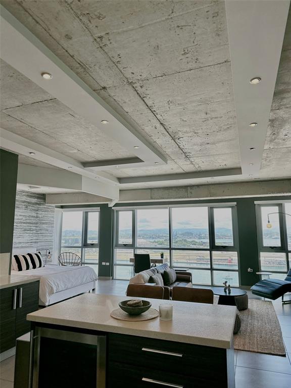 A modern open-concept apartment features a concrete ceiling, kitchen island, and floor-to-ceiling windows with views — 404 CONSTITUCION AVE AVENUE UNIT 1706, SAN JUAN, PR