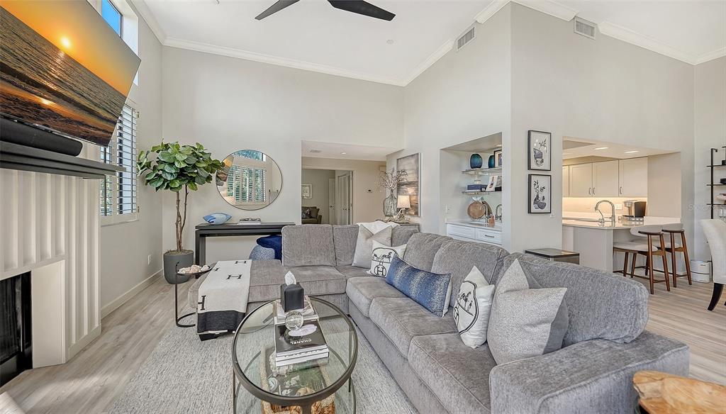 A living room features a grey sectional sofa, a glass coffee table, and a fireplace — 2000 HARBOURSIDE DRIVE UNIT 1501, LONGBOAT KEY, FL
