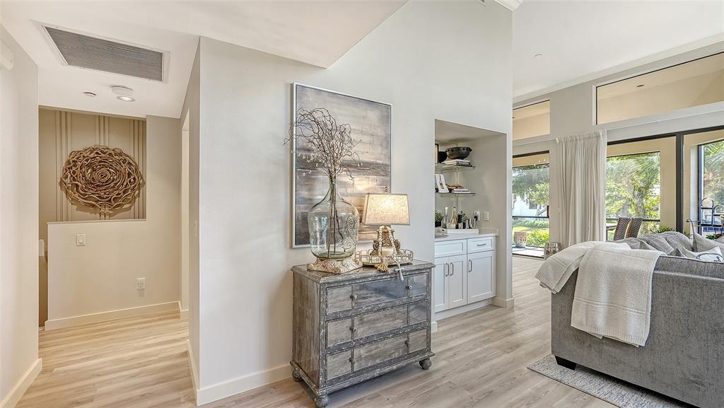 A living area features a mirrored chest, a wet bar, and a view of the outdoors — 2000 HARBOURSIDE DRIVE UNIT 1501, LONGBOAT KEY, FL