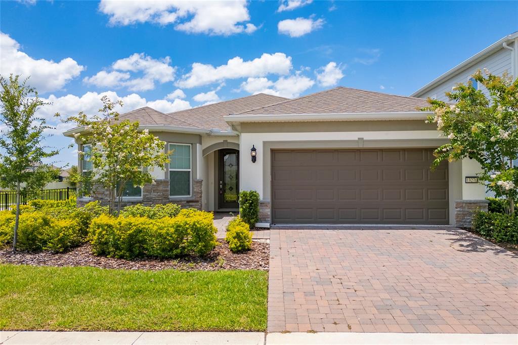 A single-story house with a paved driveway, a two-car garage, and stone accents — 13270 PANAMA BEACH COURT, ORLANDO, FL