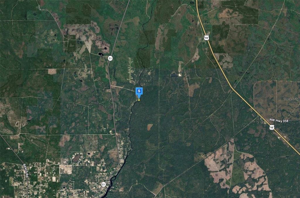 This is an aerial satellite map showing a property location surrounded by forest and roads — 1960 RIVER ROAD, STEINHATCHEE, FL