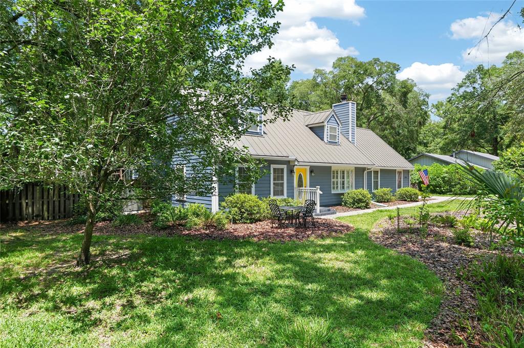 A blue two-story house with a metal roof and a yellow front door — 5101 NW 65TH LANE, GAINESVILLE, FL
