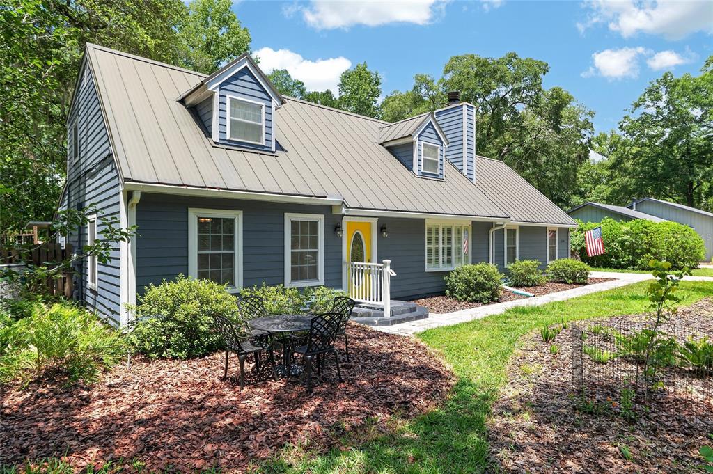 A blue two-story house with a metal roof and a yellow front door — 5101 NW 65TH LANE, GAINESVILLE, FL
