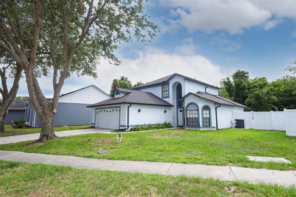 A two-story house with a white exterior, blue trim, and an attached two-car garage — 1152 TWIN RIVERS BOULEVARD, OVIEDO, FL