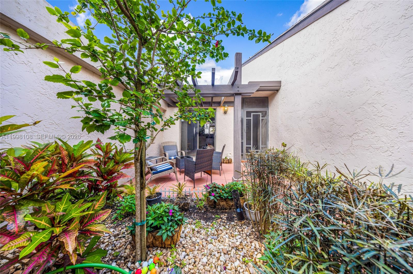 A patio area features a pergola, outdoor furniture, and a small garden with gravel — 5302 Fairway Woods Dr # 4612, Delray Beach FL 33484, DELRAY BEACH, FL