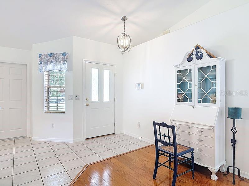 An entryway features white walls, tiled and hardwood flooring, a front door, and a hutch — 60 ROLLING SANDS DRIVE, PALM COAST, FL
