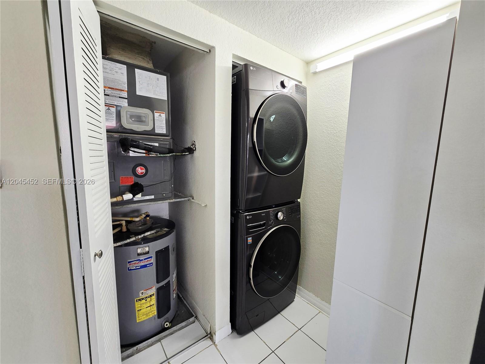 A utility closet contains a water heater and HVAC unit next to a stacked washer-dryer — 1627 NW 18th St # 201, Miami FL 33125, MIAMI, FL