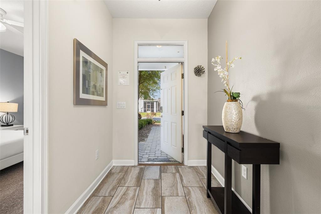 An entryway with tile flooring, a dark console table, and an open door to outside — 9044 SAND TRAP DRIVE, DAVENPORT, FL