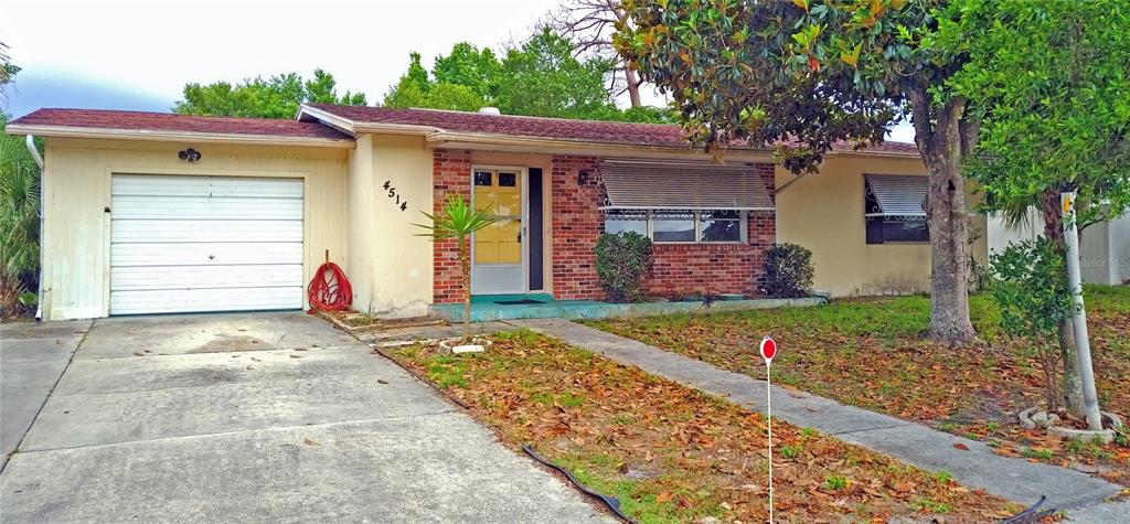 A single-story house with a brick facade, a one-car garage, and a concrete driveway — 4514 CYNTHIA LANE, SPRING HILL, FL