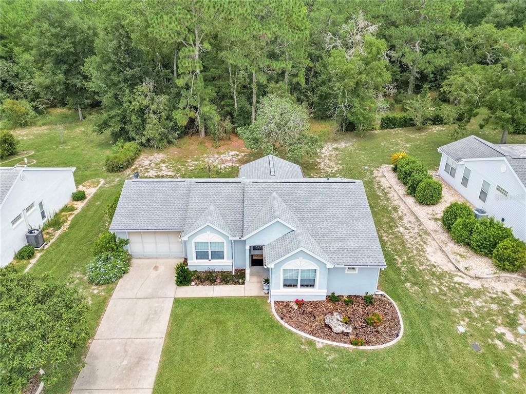 An aerial view shows a light blue single-story house with a gray shingled roof — 8795 SW 108TH STREET, OCALA, FL