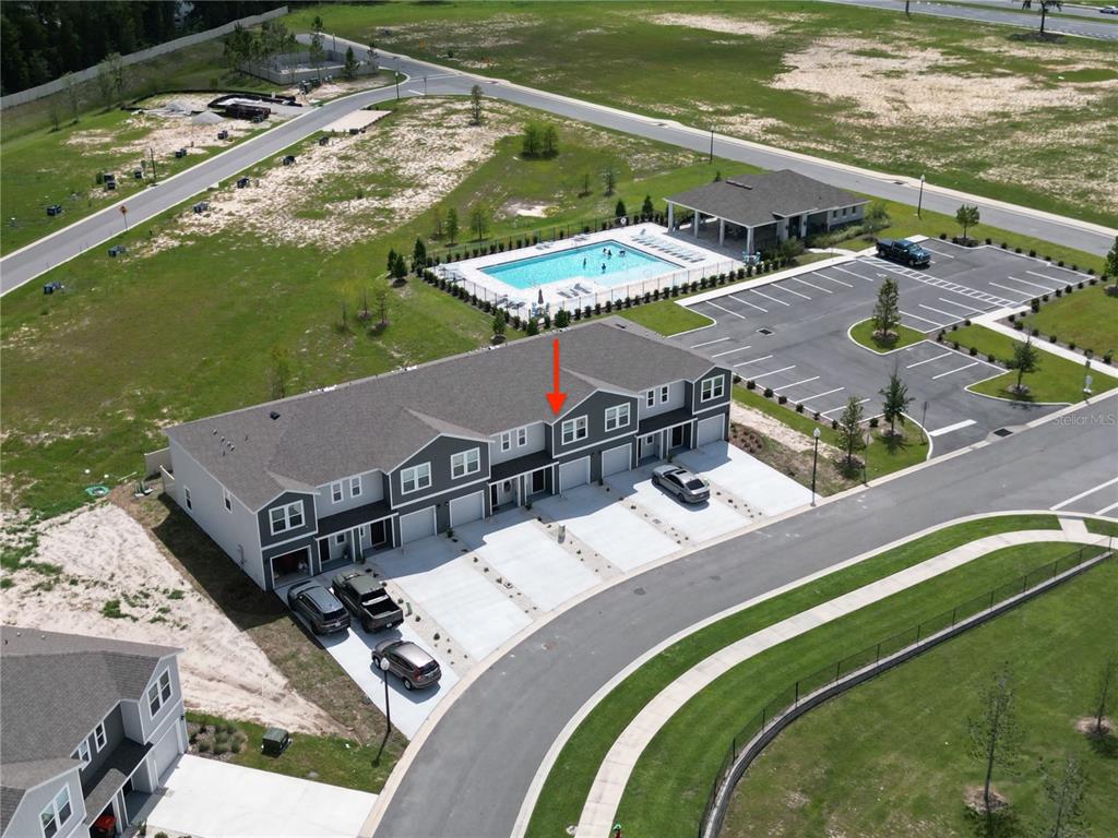 An aerial view shows a row of townhomes with a community pool nearby — 6524 SW 82ND LOOP, OCALA, FL