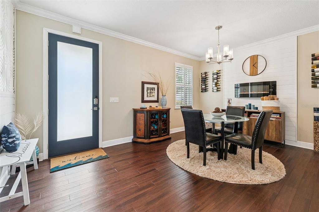 A dining area features a glass table, four black chairs, and a fireplace on shiplap — 112 SLIPPER KEY ROAD, APOLLO BEACH, FL