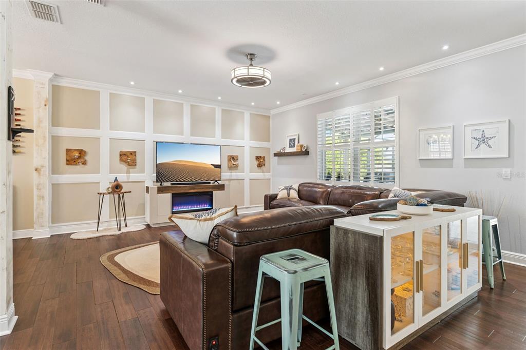A living room features a brown leather sectional, a fireplace, and wall paneling — 112 SLIPPER KEY ROAD, APOLLO BEACH, FL