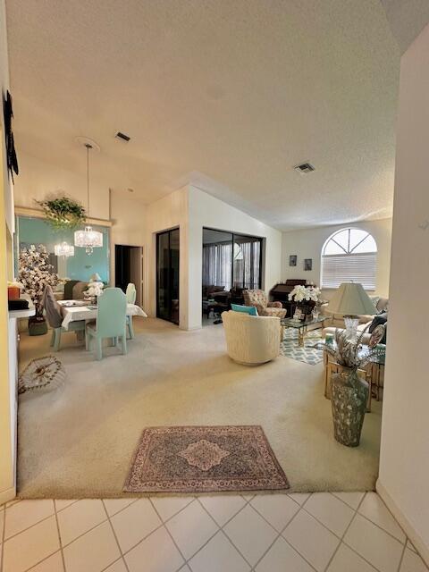 A spacious living and dining area features vaulted ceilings, beige carpeting, and large glass doors — 5406 Firenze Drive # O, Boynton Beach FL 33437, BOYNTON BEACH, FL