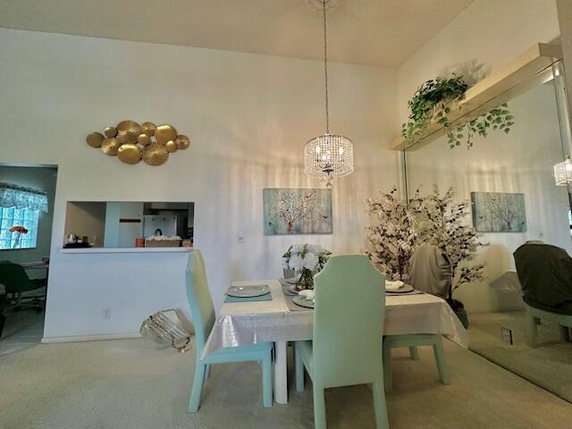 A dining room features a crystal chandelier, light green chairs, and a large wall mirror — 5406 Firenze Drive # O, Boynton Beach FL 33437, BOYNTON BEACH, FL