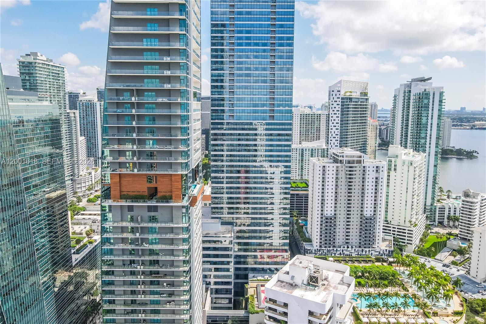 An aerial view shows multiple modern glass skyscrapers in a dense urban waterfront setting — 1451 Brickell Ave # 1004, Miami FL 33131, MIAMI, FL