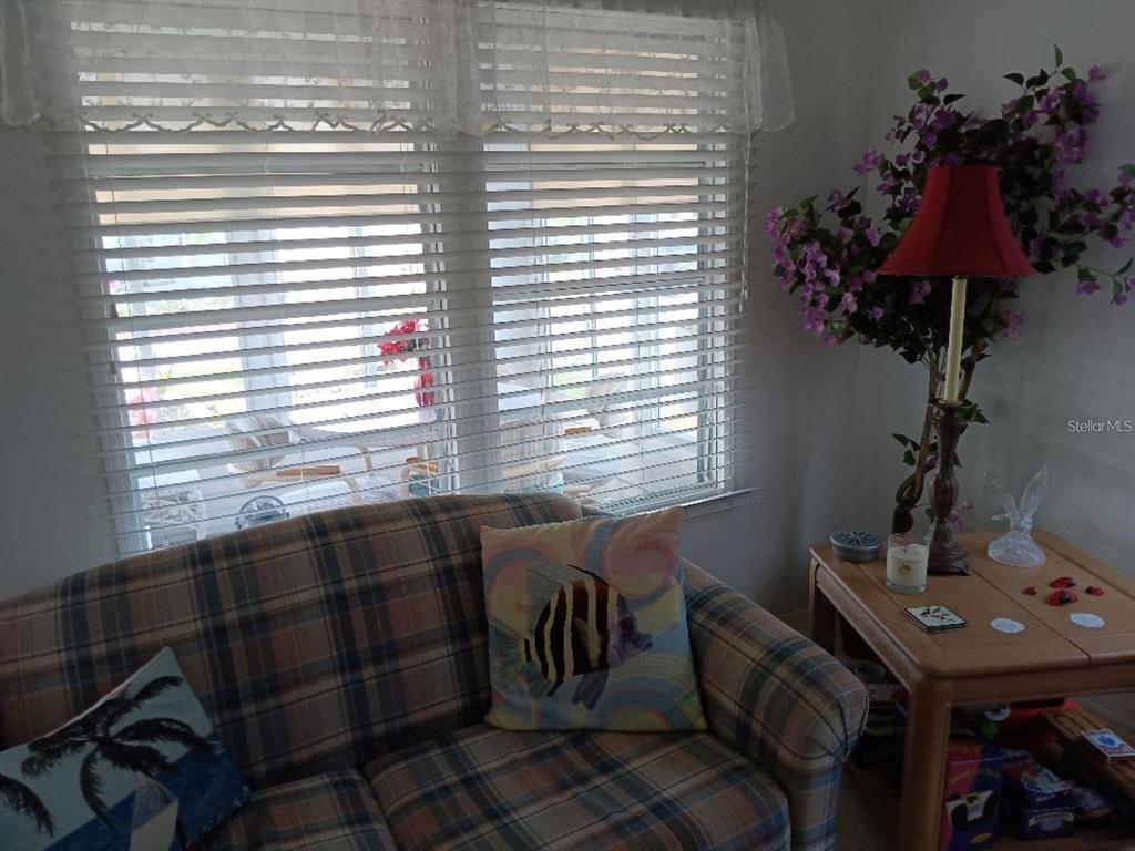 A plaid sofa sits in a living room next to a lamp with purple flowers — 638 LEISURE, VENICE, FL