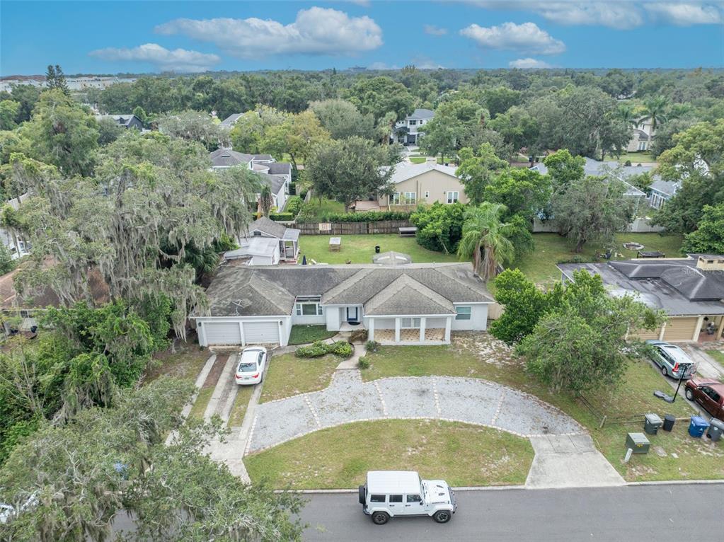 An aerial view shows a single-story house with a gravel driveway and a white vehicle — 1780 BRYAN AVENUE, WINTER PARK, FL