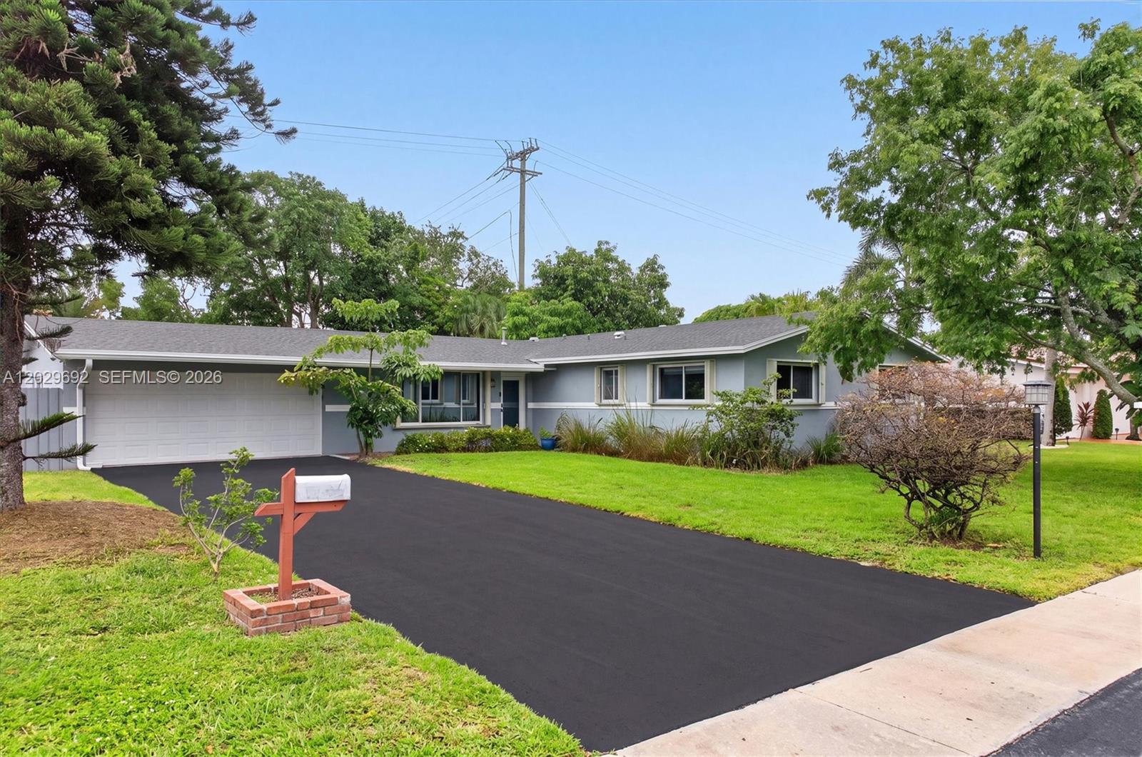 A single-story house with a gray exterior, a white garage door, and a paved driveway — 5501 Pine Ter, Plantation FL 33317, PLANTATION, FL