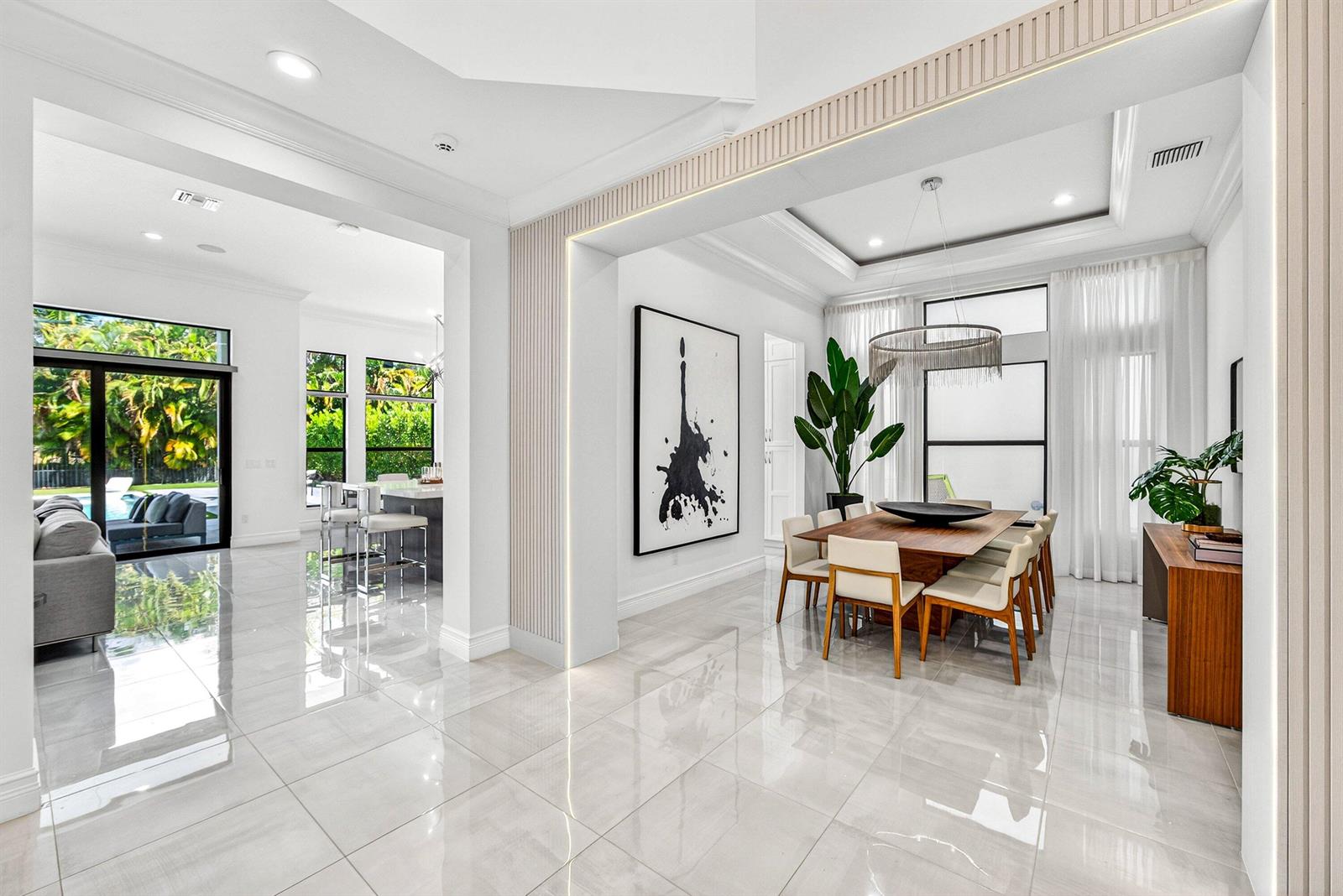 A modern dining room with a wooden table, white chairs, and large abstract wall art — 9065 Benedetta Place, Boca Raton FL 33496, BOCA RATON, FL