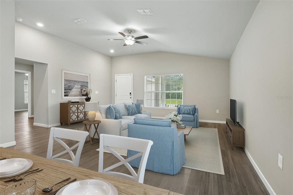 A living room features light gray walls, wood-look flooring, blue furniture, and a ceiling fan — 5494 SE 91ST STREET, OCALA, FL