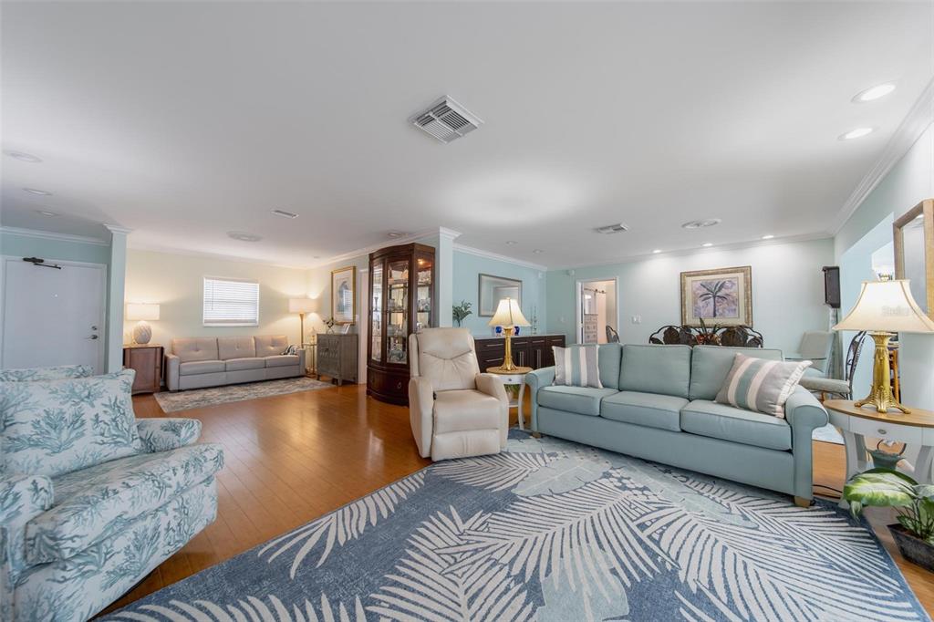 A spacious living room features light blue walls, hardwood floors, and two separate seating areas — 5020 BRITTANY DRIVE S UNIT 324, ST PETERSBURG, FL