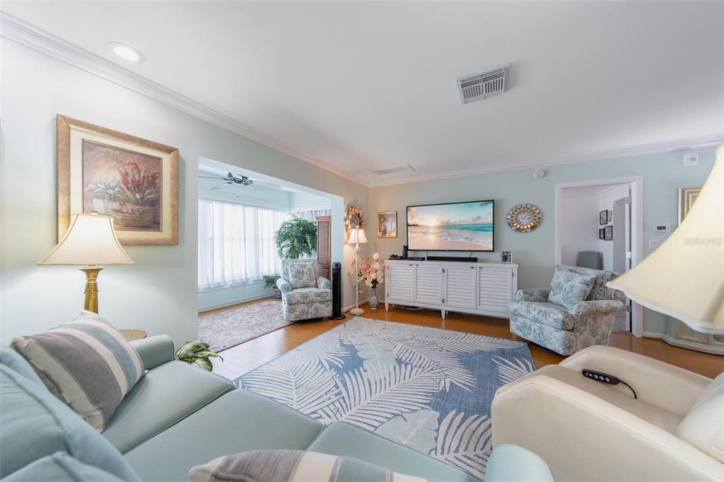 A living room with light blue walls, a patterned area rug, and a television console — 5020 BRITTANY DRIVE S UNIT 324, ST PETERSBURG, FL