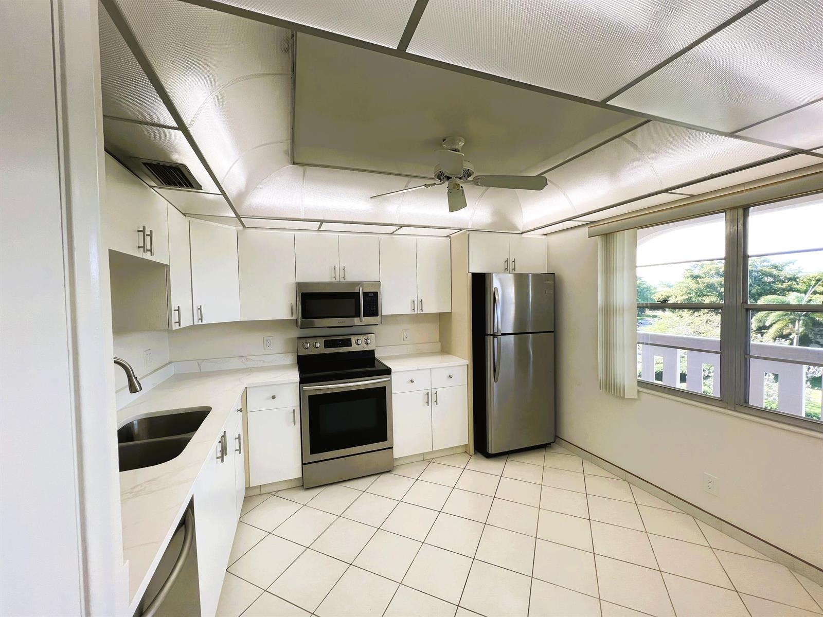 A kitchen with white cabinets, stainless steel appliances, white countertops, and a ceiling fan — 3303 Aruba Way # 4, Coconut Creek FL 33066, COCONUT CREEK, FL