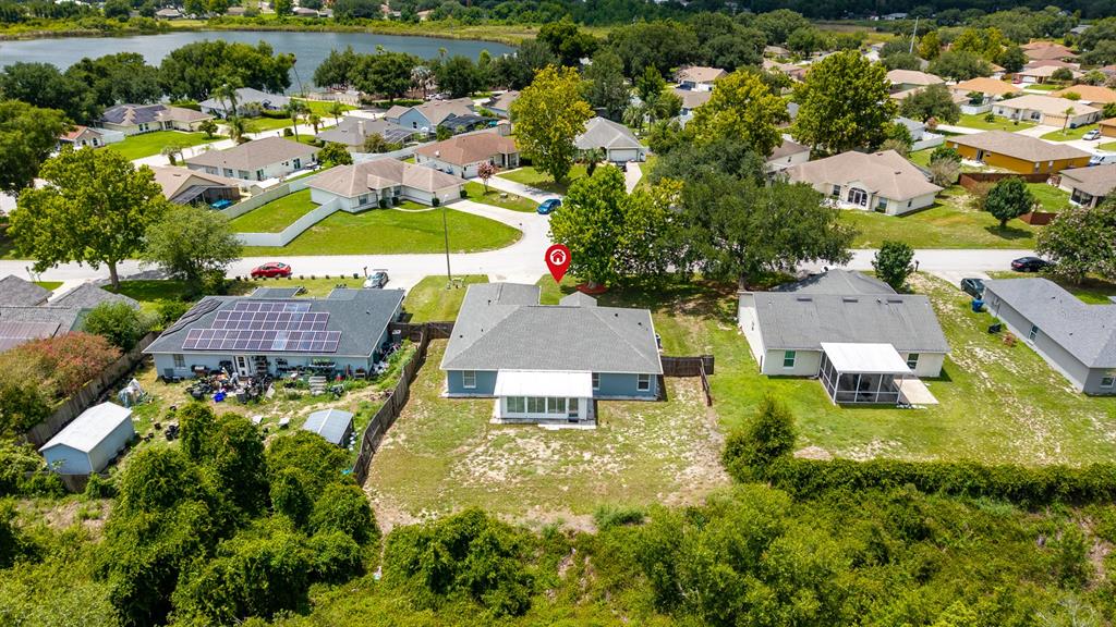 An aerial view shows a residential neighborhood with a marked house and surrounding properties — 148 COUNTRY LAKES CIRCLE, GROVELAND, FL