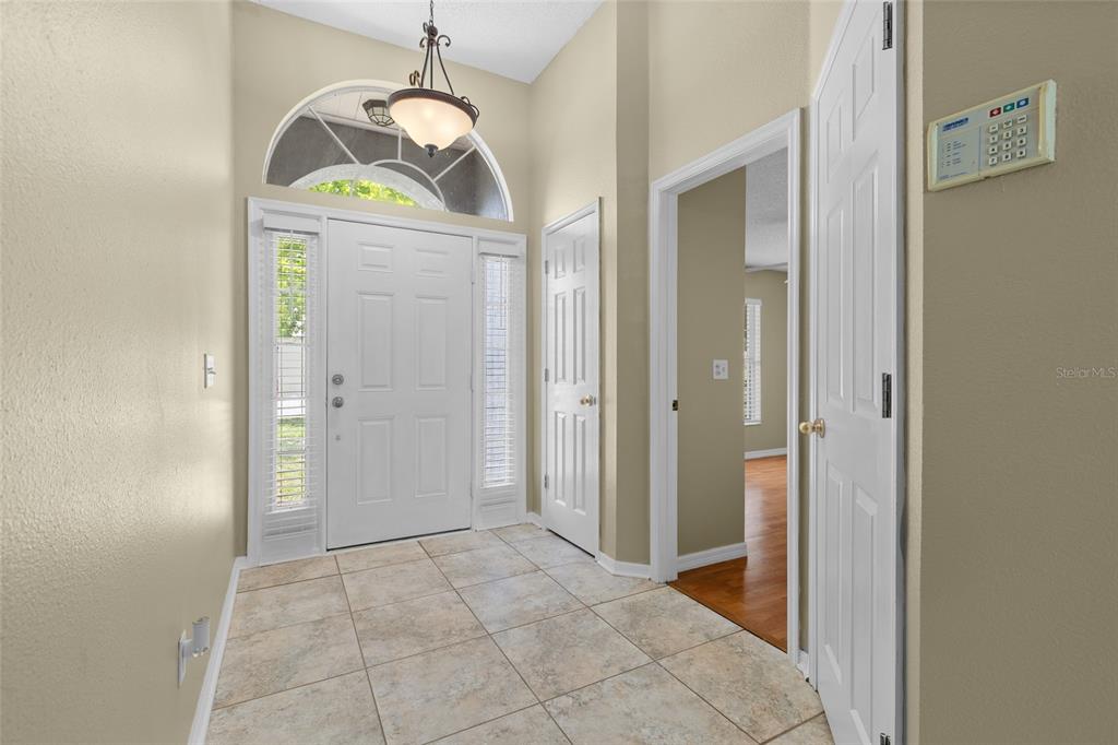 An entryway features tile flooring, a white front door with sidelights, and a light fixture — 148 COUNTRY LAKES CIRCLE, GROVELAND, FL