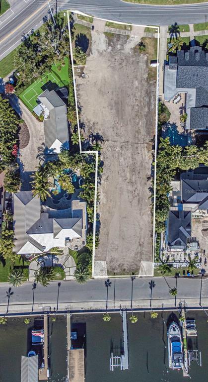 An aerial view shows a vacant, rectangular waterfront lot situated between two residential properties — 140 BRIGHTWATERS BOULEVARD NE, ST PETERSBURG, FL