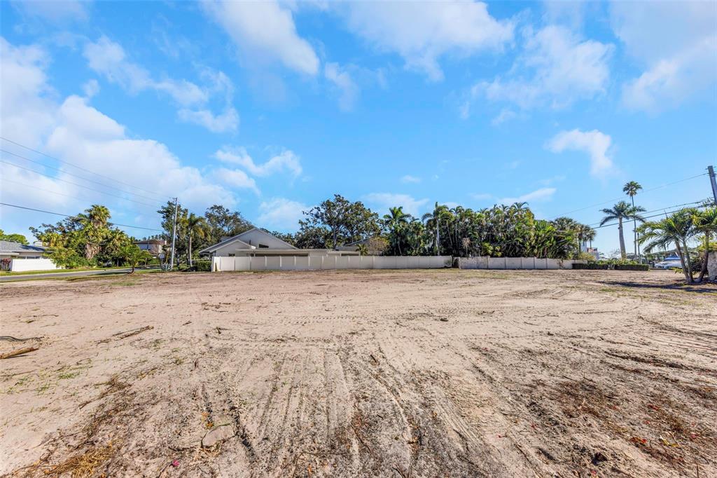 A large, cleared, sandy vacant lot with a white fence and palm trees in back — 140 BRIGHTWATERS BOULEVARD NE, ST PETERSBURG, FL