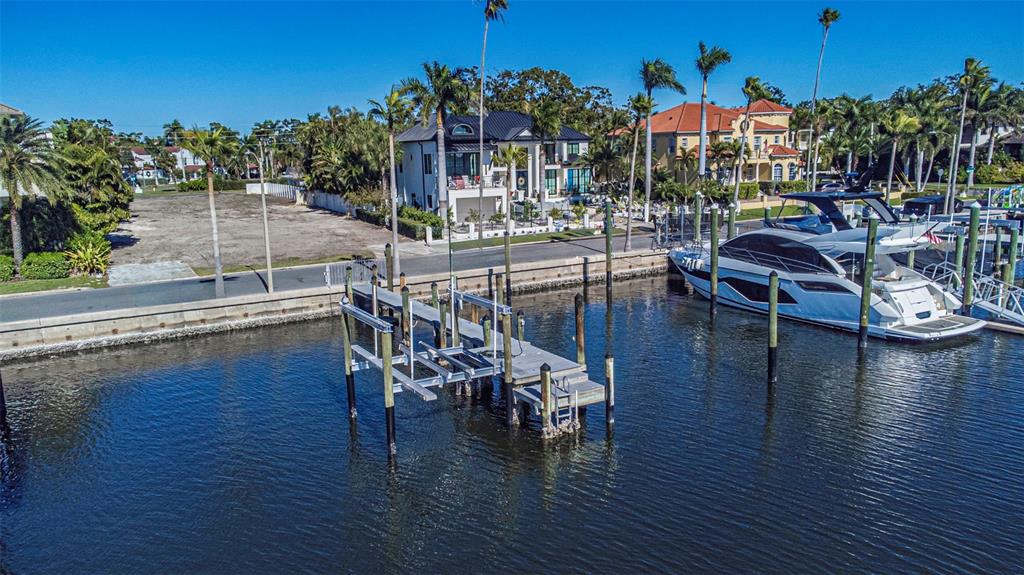 An aerial view shows a boat lift in a canal next to a waterfront property — 140 BRIGHTWATERS BOULEVARD NE, ST PETERSBURG, FL