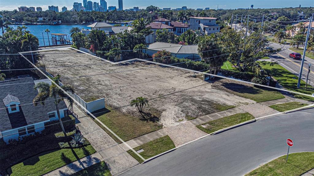 An aerial view shows a vacant, cleared residential lot bordered by a street and houses — 140 BRIGHTWATERS BOULEVARD NE, ST PETERSBURG, FL