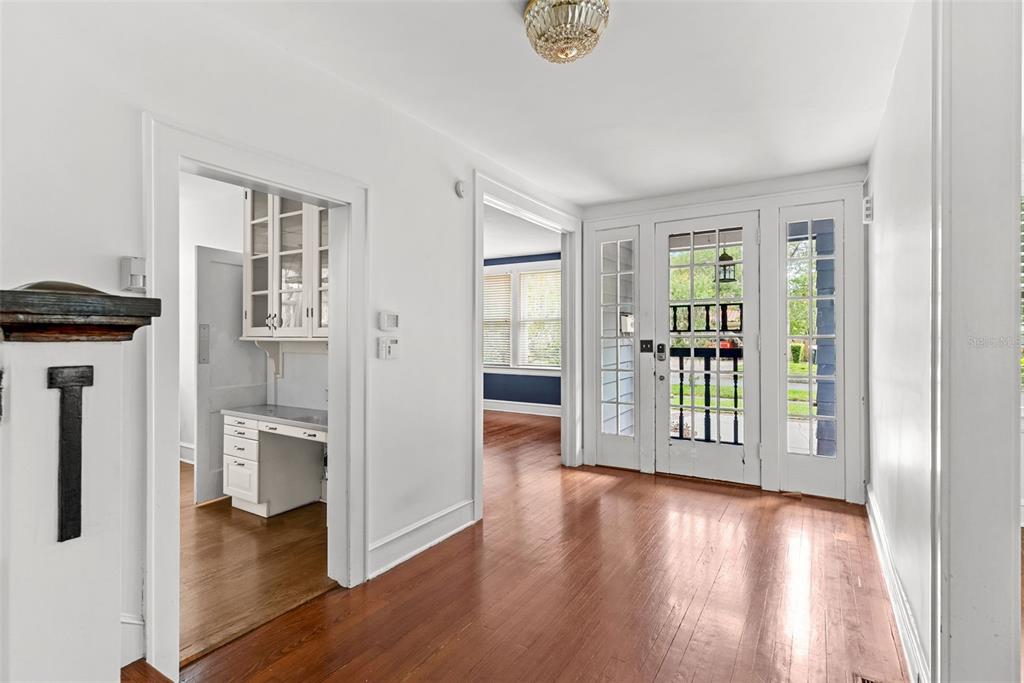 An entryway with hardwood floors leads to a kitchen nook and a front door — 418 JASMINE WAY, CLEARWATER, FL