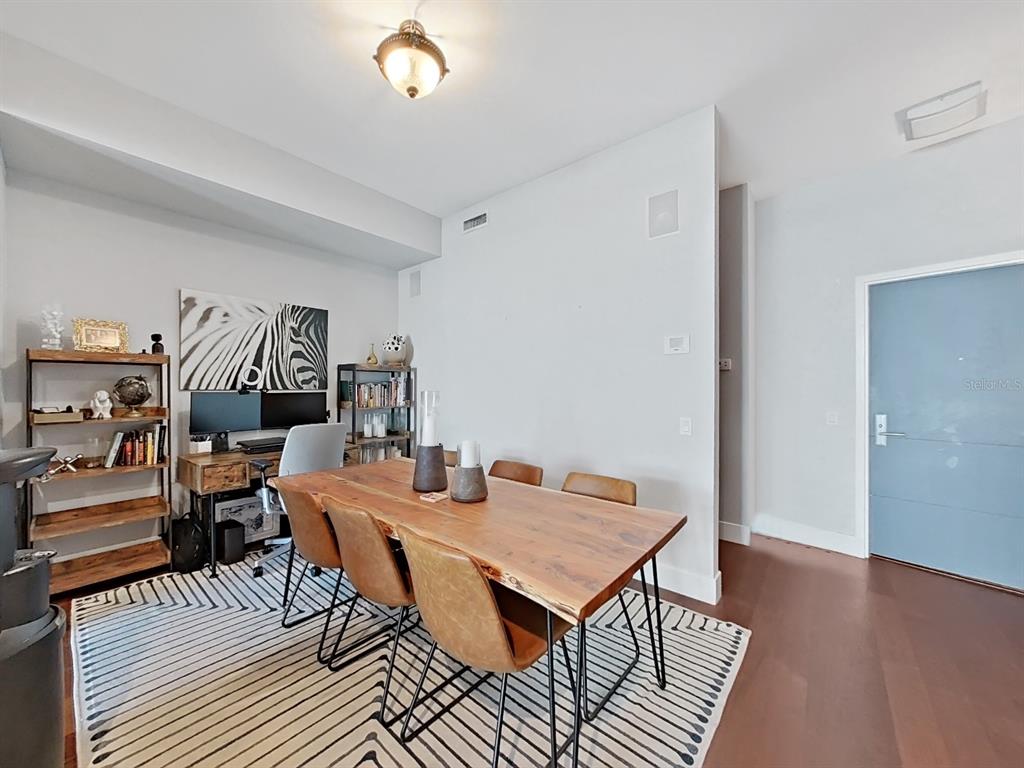 A dining room features a live-edge wood table, leather chairs, and a home office area — 111 N 12TH STREET UNIT 1810, TAMPA, FL