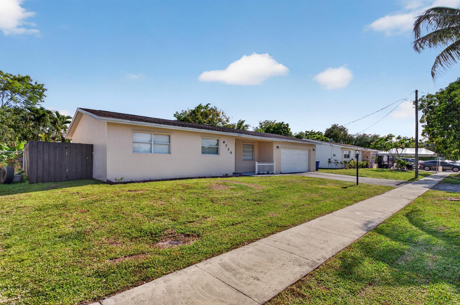 A single-story house with a tan exterior, a white garage door, and a front lawn — 6720 NW 26th Street, Margate FL 33063, MARGATE, FL