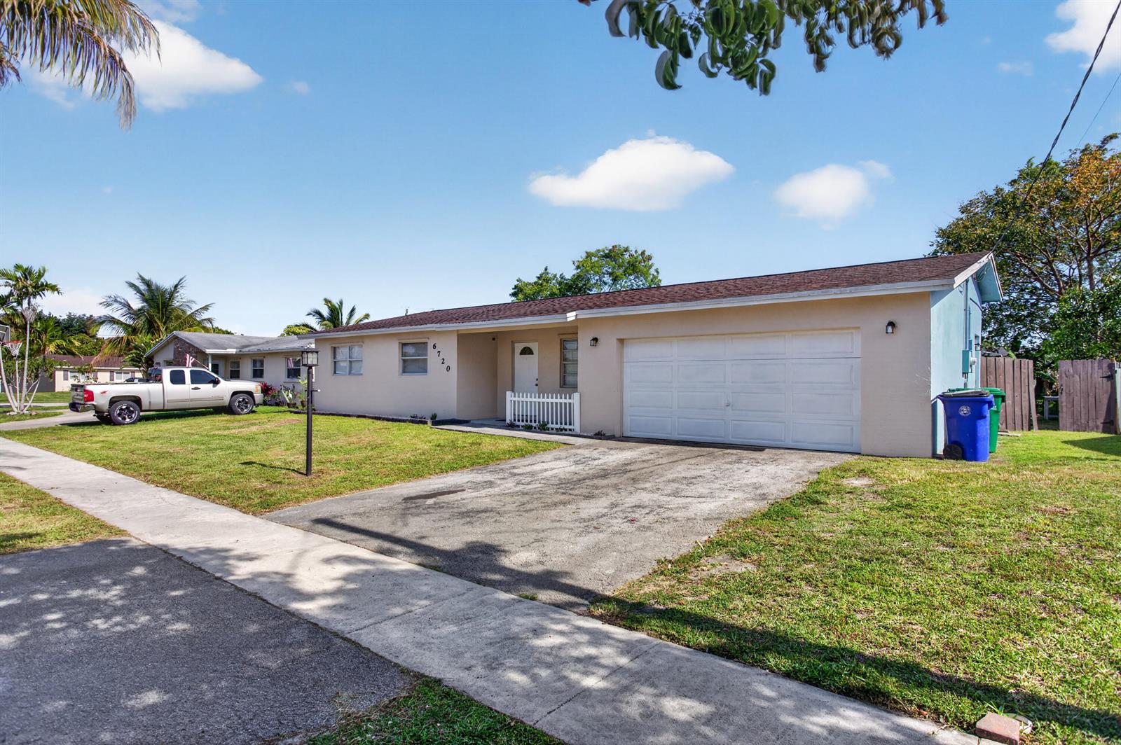 A single-story house with a beige exterior, a white garage door, and a concrete driveway — 6720 NW 26th Street, Margate FL 33063, MARGATE, FL