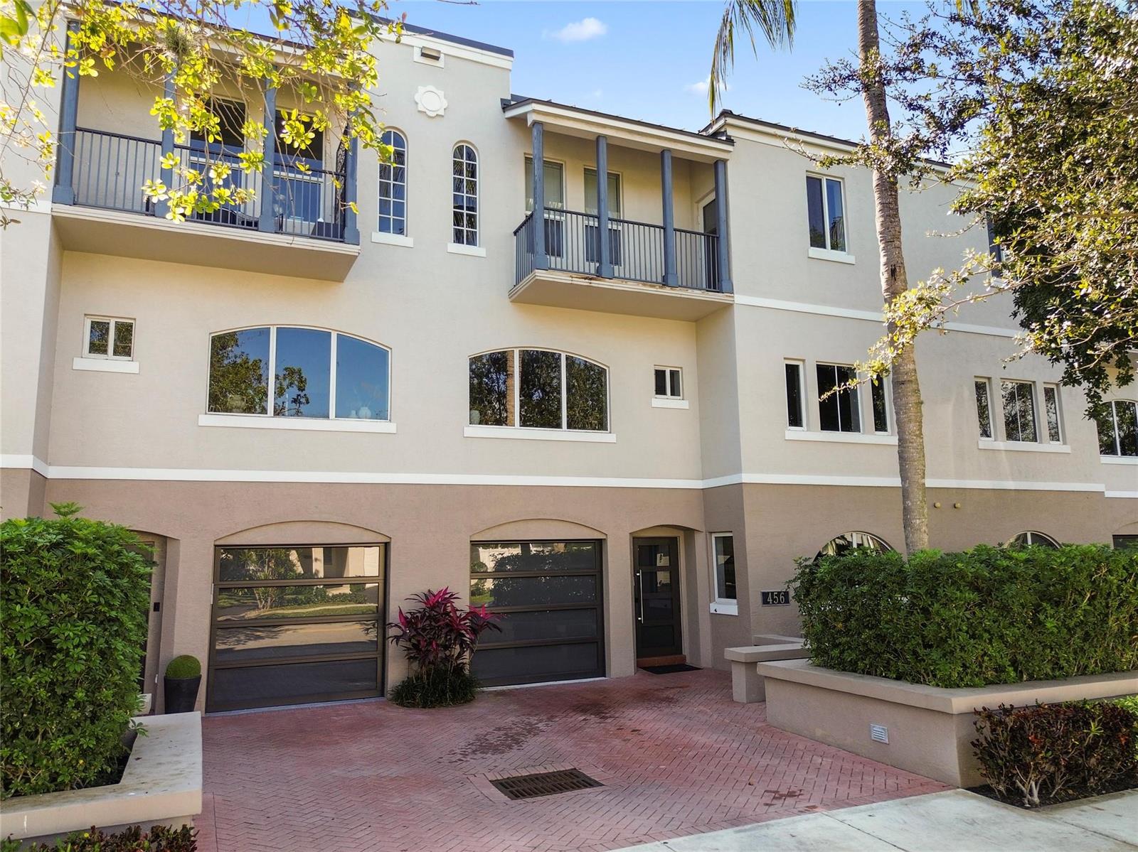 A three-story townhouse exterior features two garage doors, a front entrance, and two upper balconies — 456 E Boca Raton Road, Boca Raton FL 33432, BOCA RATON, FL