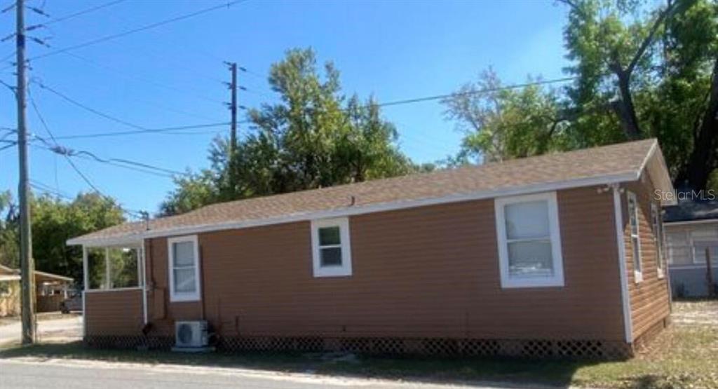 A tan, single-story house with brown siding and a shingled roof sits on a lot — 1810 N BRACK STREET, KISSIMMEE, FL